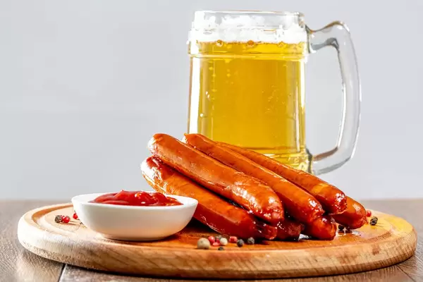 Light beer with grilled sausages and ketchup