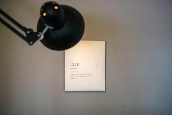 Light of a Lamp pointing at Definition of Love on a White Background as Wall Photo