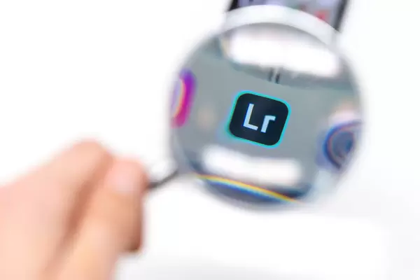 Lightroom App Icon durch Lupe betrachtet vor weißem Hintergrund