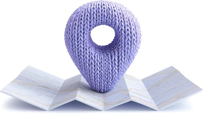 Lila gestrickter Kartentisch-Marker auf geometrischem Papierhintergrund