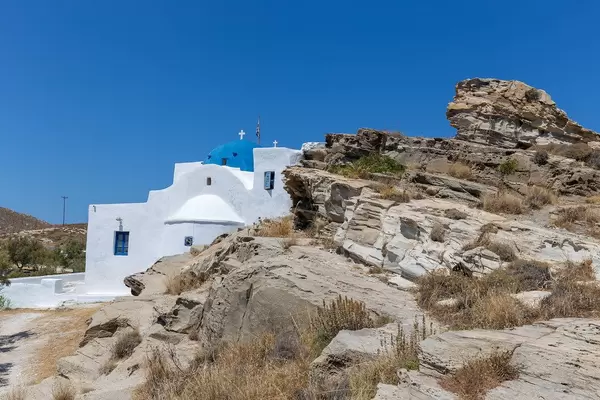 Limestone monastery St. John's of Deti, with blue dome, in the environmental park of Paros on Greece, built on a rocky coast at the Aegean Sea