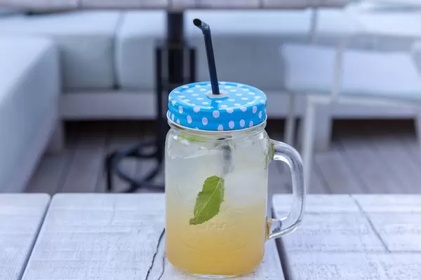 Limonade mit Minze und viel Eis in einem Halbliterglas mit Deckel und Trinkhalm