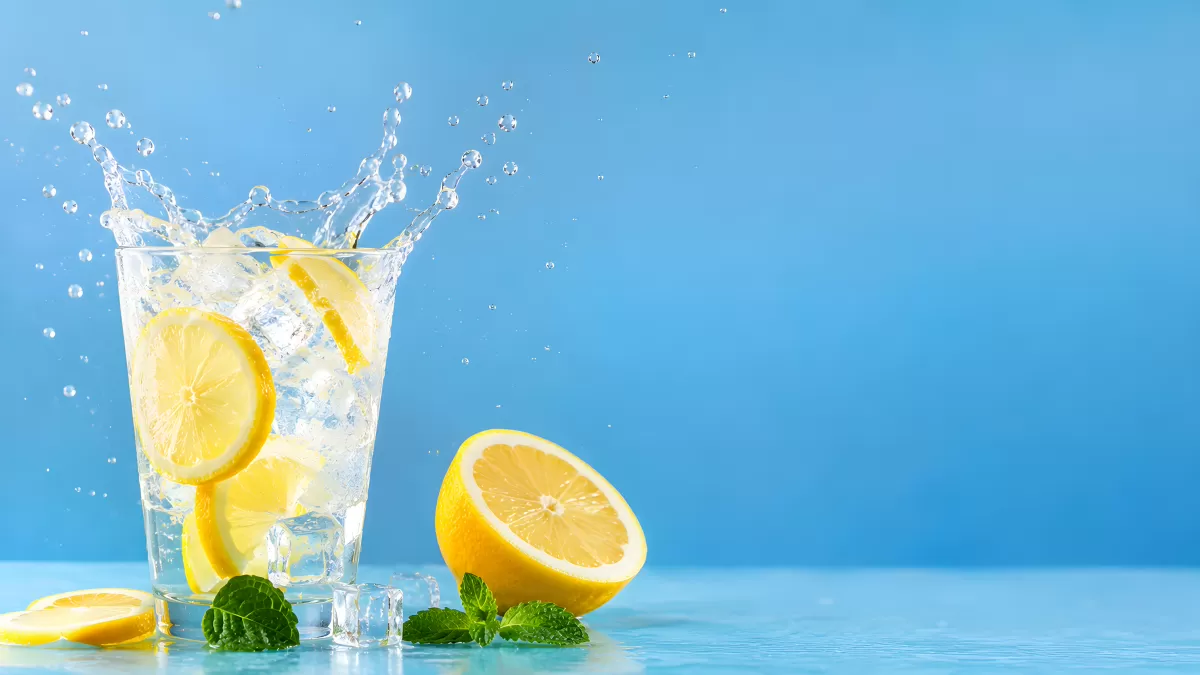 Limonade mit Zitrone und Minze spritzt aus Glas