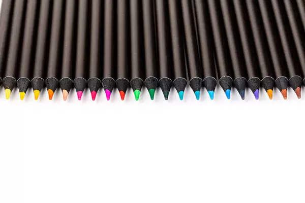 Line of colored pencils on white