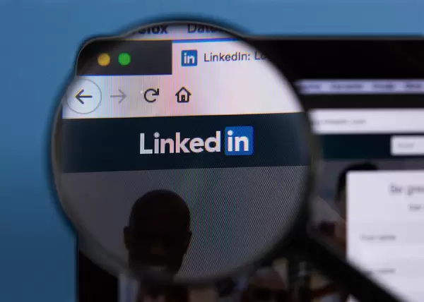 Linkedin-Logo am PC-Monitor, durch eine Lupe fotografiert