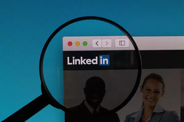 Linkedin Schriftzug und Logo, vergrößert dargestellt durch eine Lupe