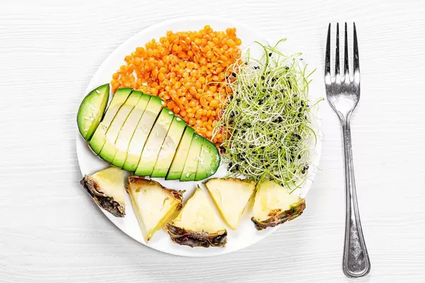 Linsen mit Keimsprossen, geschnittener Avocadofrucht und Ananas