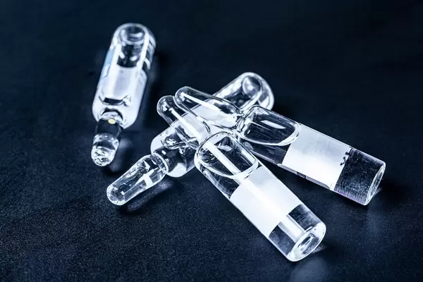 Liquid medicinal agent in limpid glassware on black background