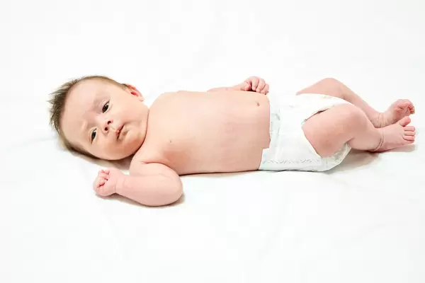 Little baby boy lying on white bed