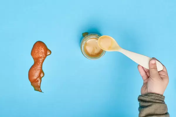 Little kid playing with puree