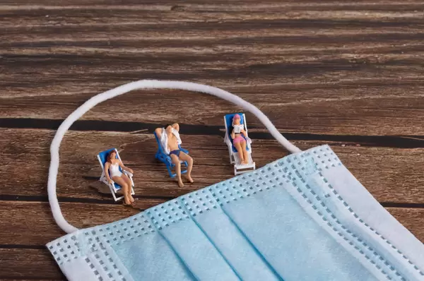 Little miniature people sunbathing on a beach