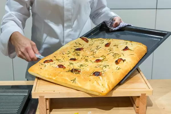 Live cooking show by Miele with German TV-chef Bettina Seitz at IFA in Berlin: Focaccia - Ligurian flatbread with herbs on a baking tray