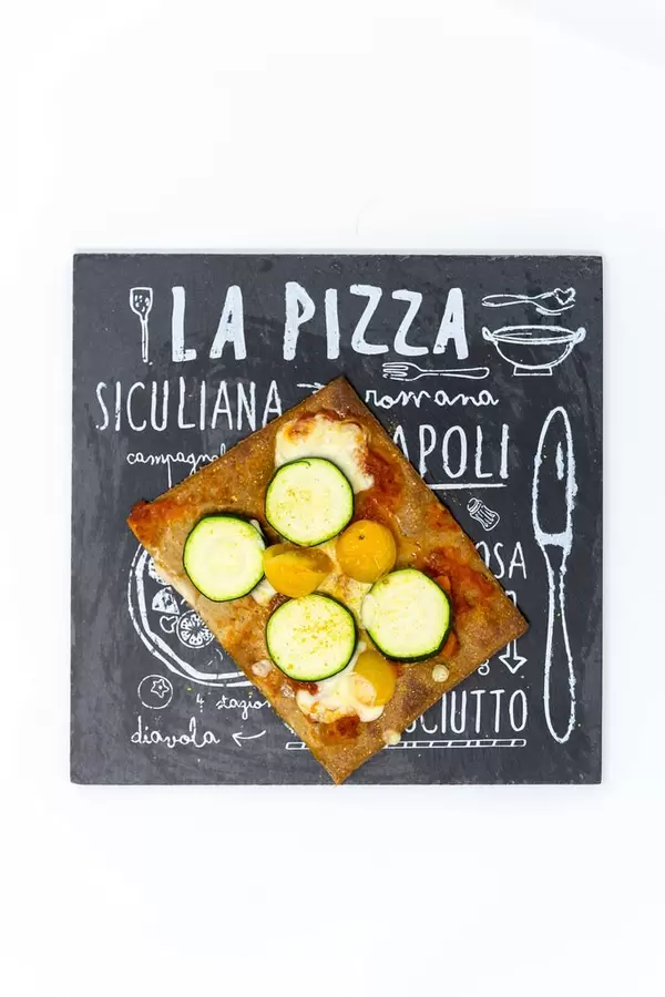 Lizza Veganer low carb Pizzaboden aus Chia und Leinsamen mit gelben Kirschtomaten, Zucchini und Käse