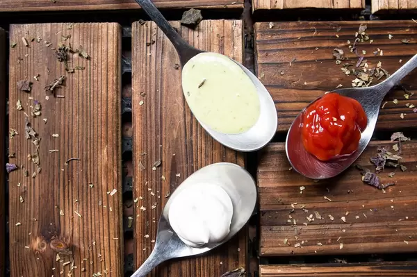 Löffel mit Ketchup und Majonäse