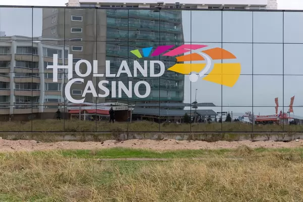 Logo des Holland Casinos auf der verglasten Fassade mit Spiegelung der Umgebung