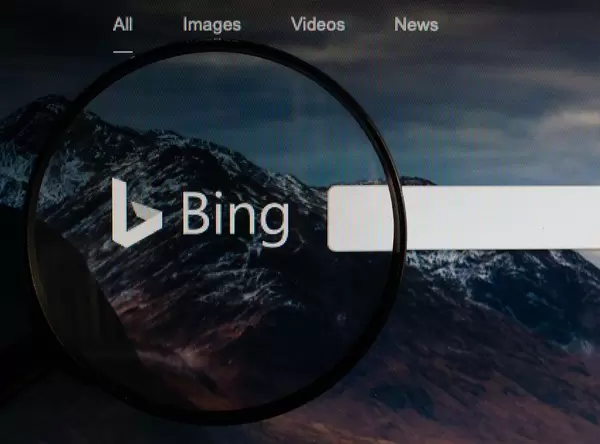Logo und Schriftzug der Suchmaschine Bing, vergrößert durch eine Lupe dargestellt