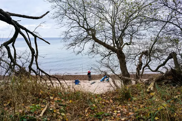 Lone fisherman on the Baltic sea coast with a fishing rod