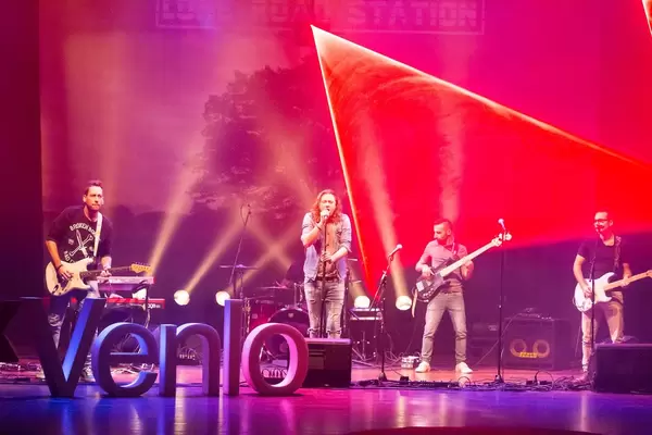 Lone Road Station & Laserforum on the stage with Venlo sign in the foreground - TEDxVenlo 2017