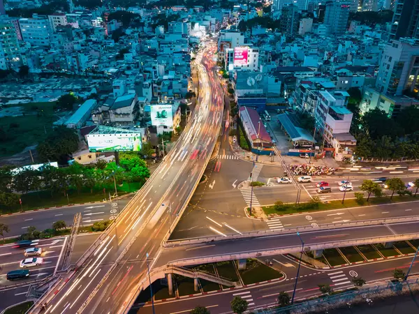 Long Exposure Drone Photo with Traffic Light Streaks on a Bridge over a Highway with many Buildings in Ho Chi Minh City, Vietnam