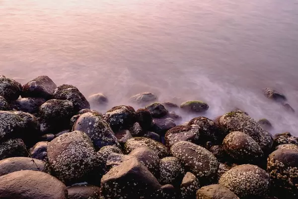 Long exposure of small waves hitting rocks