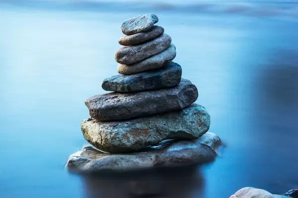 Long Exposure Photo of Stones stacked on each other in the Water