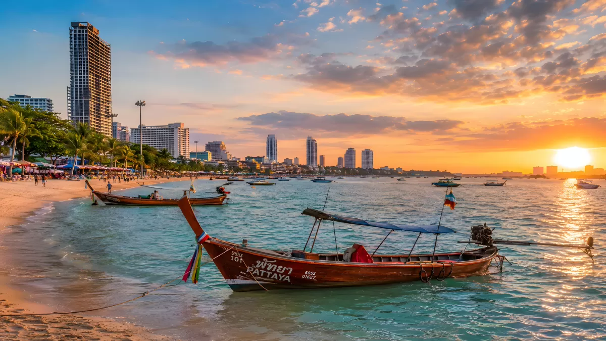 Longtailboote am Strand von Pattaya bei Sonnenuntergang