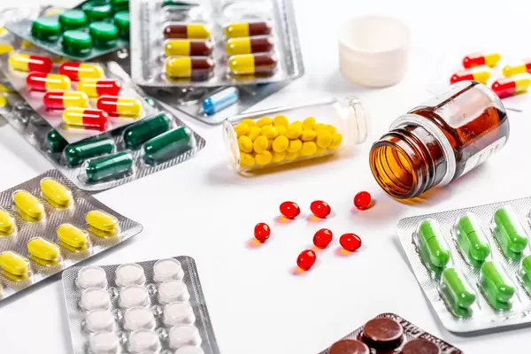 Lots of colorful and different shapes of pills, pills and capsules on white background (Flip 2019)