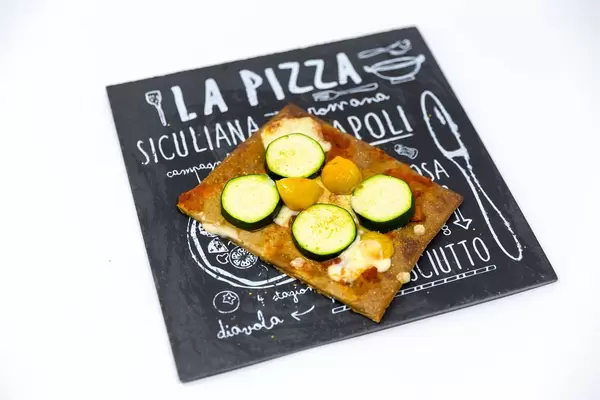 Low Carb Pizzaboden aus Chia und Leinsamen belegt mit Zucchini, Kirschtomaten und Käse