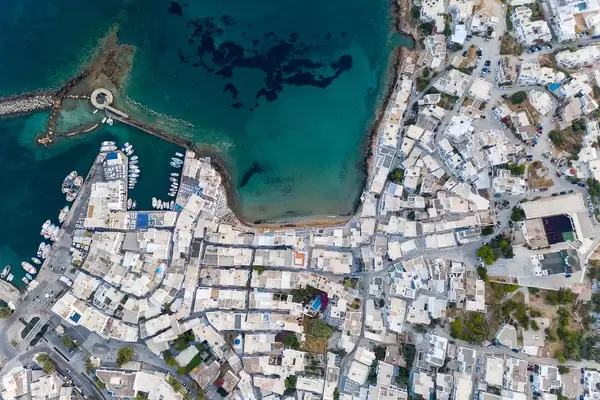 Luftaufnahme der Hafenstadt Naoussa, im nördlichen Teil der Insel Paros, mit den Ruinen eines venezianischen Schloss' im Mittelmeer