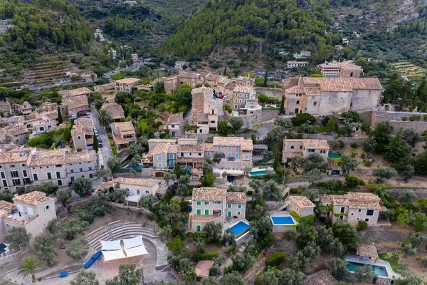 Luftaufnahme der Häuser von Deià mit Pools mitten im Grünen. Künstlerdorf an der Westküste Mallorcas