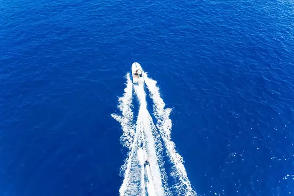 Luftaufnahme der Wassersportart Wasserski, hinter einem Schnellboot, auf dem Myrtoischen Meer
