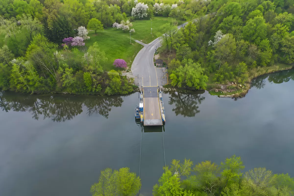Luftaufnahme einer Fähre an einem Fluss im Frühling