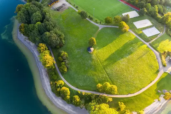 Luftaufnahme einer riesigen Grünfläche in der Stadt Leeberg am Ufer des Tegernsees