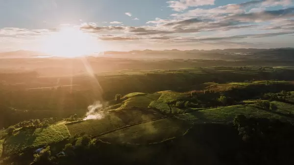 Luftaufnahme Sonnenstrahlen treffen auf Felder und Natur in Don Salvador, Negros, Philippinen