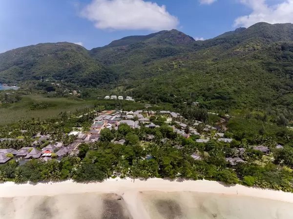 Luftaufnahme vom Constance Ephelia Resort vor den grünen Hügeln des Morne Nationalpark auf den Seychellen mit Port Launay Strand