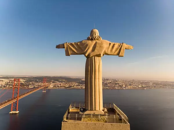 Luftaufnahme von Cristo Rei Statue von hinten in Almada Lissabon