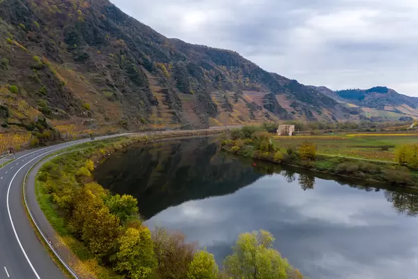 Luftaufnahme von der Bundesstraße B49 entlang der Mosel mit im Fluss reflektierendem Randhöhenzug Calmont in Bremm, Deutschland