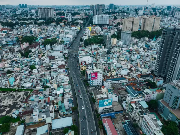 Luftaufnahme von einer Straße mit viel Verkehr, vielen Häusern und Regierungsgebäuden in Distrikt 1 in Ho Chi Minh Stadt, Vietnam