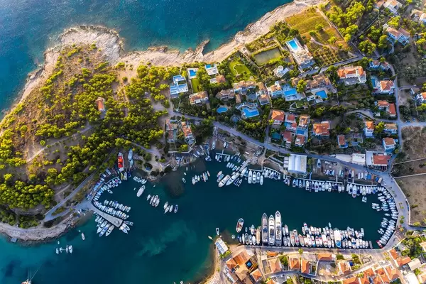 Luftaufnahme von mediterranen Villen und Schiffen im Hafen der Saronische Insel Spetses in Griechenland