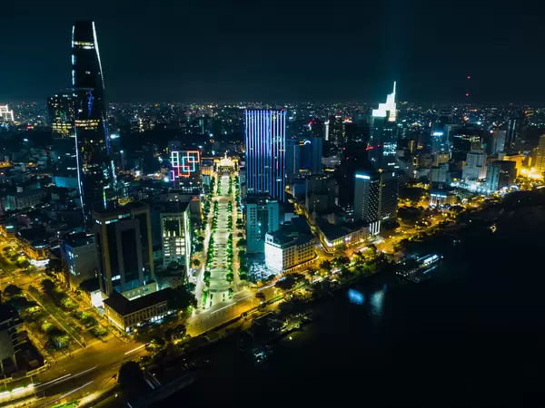 Luftaufnahme von Nguyen Hue Fußgängerzone neben dem Bitexco Financial Tower im Distrikt 1 bei Nacht in Ho Chi Minh Stadt, Vietnam