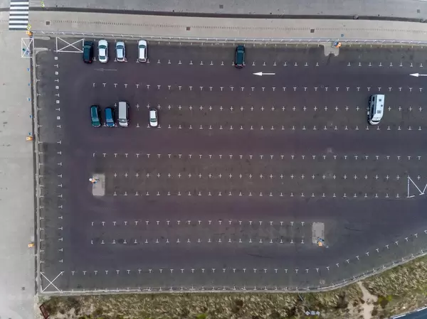 Luftaufnahme von riesiger Parkfläche mit nur wenigen geparkten Fahrzeugen