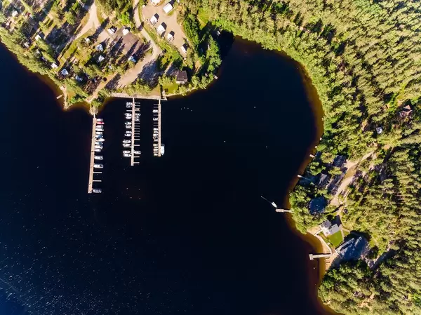 Luftaufnahme zeigt Jachten und Motorboote an Holzstegen auf dem Päijännesee bei Padasjoki geparkt, neben luxuriösen Ferienhäuser
