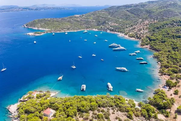 Luftaufnahme zeigt Katamarane und teure Boote in der Bucht am Ekklisia Analipsi Küste der griechischen Insel Spetses