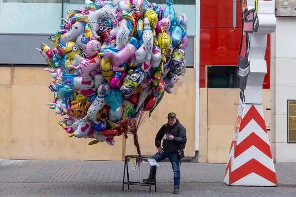 Luftballonverkäufer liest eine Nachricht auf seinem Handy