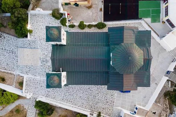 Luftbild der Hauptkirche mit grünem Dach, von oben, mit Steinveranda, in Naoussa, Paros, Griechenland