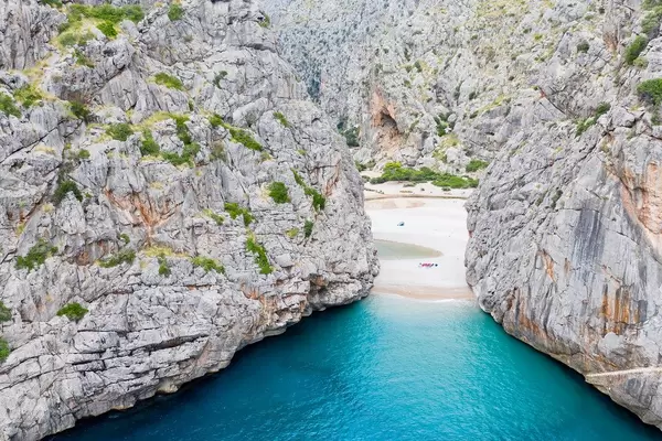 Luftbild: Der versteckte Strand von Sa Calobra, Mallorca. Türkises Wasser zwischen steilen Klippen