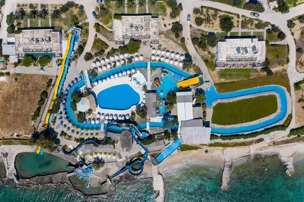 Luftbild des Aqua Paros Wasserparks auf einer griechischen Insel, mit Pool und Wasserrutschen, direkt am Mittelmeer