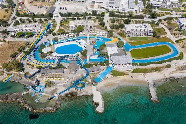 Luftbild des Wasserparks "Aqua Paros" in Naoussa, Griechenland, mit langen Wasserrutschen, die ins Mittelmeer führen
