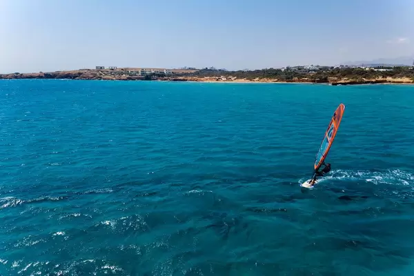 Luftbild eines Mannes auf einem Windsurfbrett auf den Wellen des Meeres vor Paros, Griechenland
