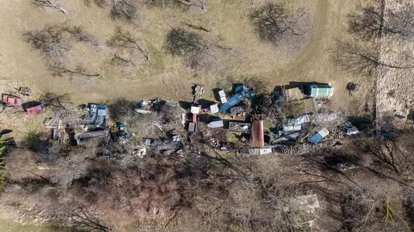 Luftbild eines Schrottplatzes am Waldrand. Ländliche Gegend
